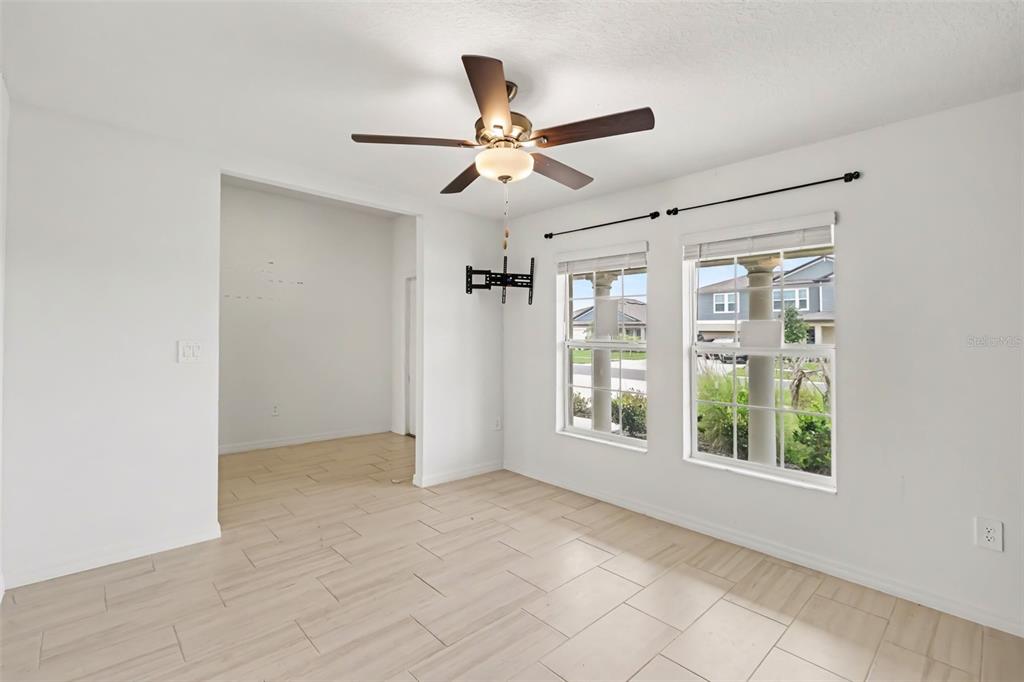 A bright room with white walls, light tile flooring, a ceiling fan, and two windows — 15281 ZIRCON RED DRIVE, WIMAUMA, FL