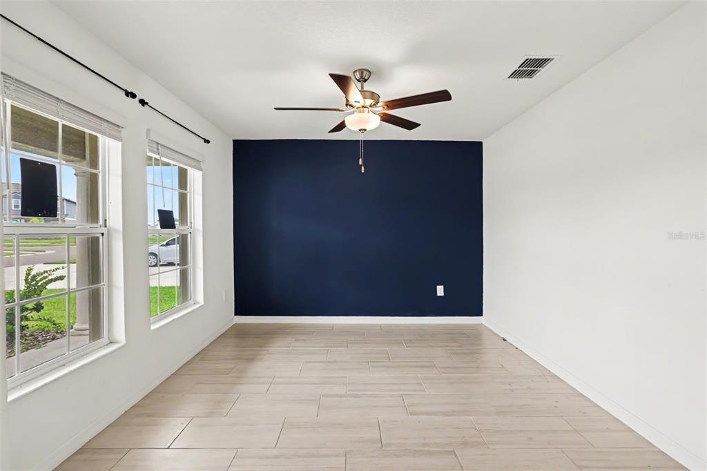 A room with light-colored tile flooring, white walls, and a dark blue accent wall — 15281 ZIRCON RED DRIVE, WIMAUMA, FL
