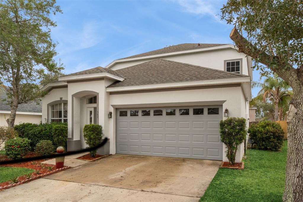 A two-story house with a gray garage door, white stucco exterior, and a concrete driveway — 367 HICKORY SPRINGS PLACE, DEBARY, FL