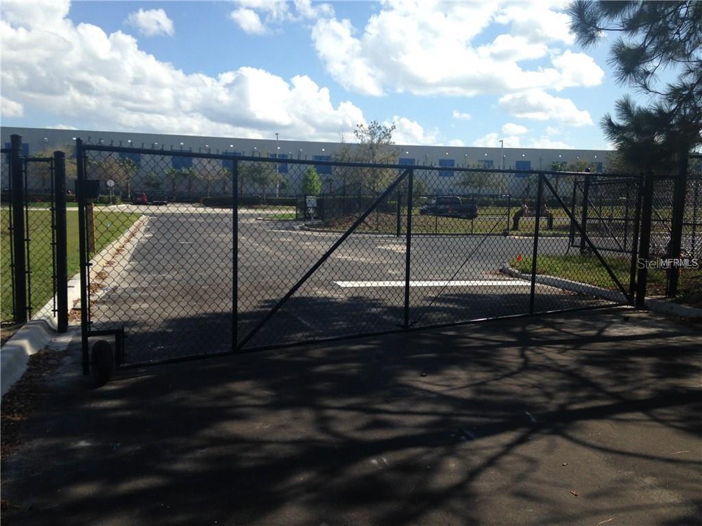 A black chain-link gate secures the entrance to a paved parking lot — 857 JETSTREAM DRIVE LOT B, ORLANDO, FL