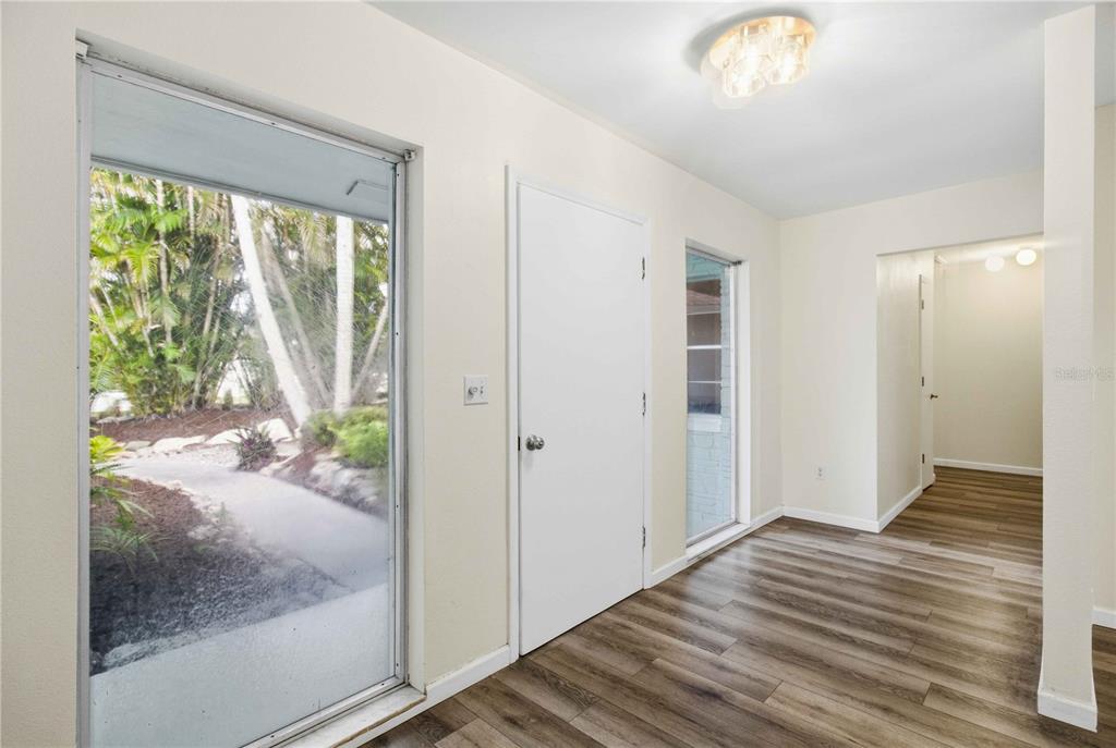 An entryway with light-colored walls, wood-look flooring, a white door, and a large window — 3629 EGERTON CIRCLE, SARASOTA, FL