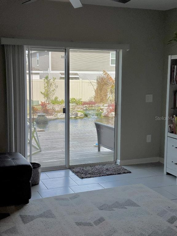 A modern kitchen features white cabinets, stainless steel appliances, a center island, and tile flooring — 5511 BRAKEN FERN WAY, LEESBURG, FL