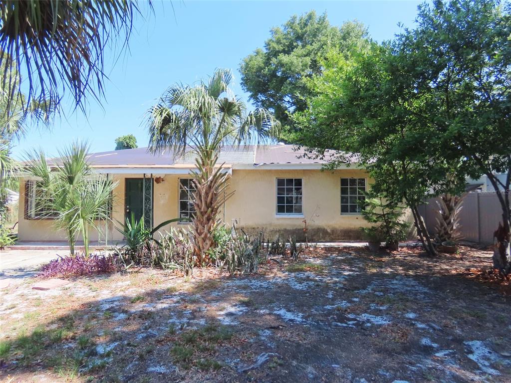 A single-story house with a yellow stucco exterior, a dark roof, and palm trees — 3911 W LEILA AVENUE, TAMPA, FL