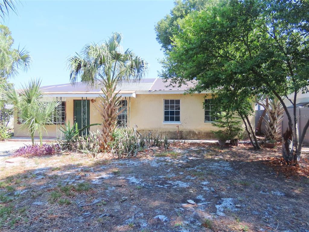 A single-story house with a yellow stucco exterior, a dark roof, and palm trees — 3911 W LEILA AVENUE, TAMPA, FL
