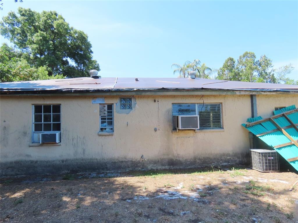 The exterior of a single-story house with a flat roof and stucco walls — 3911 W LEILA AVENUE, TAMPA, FL