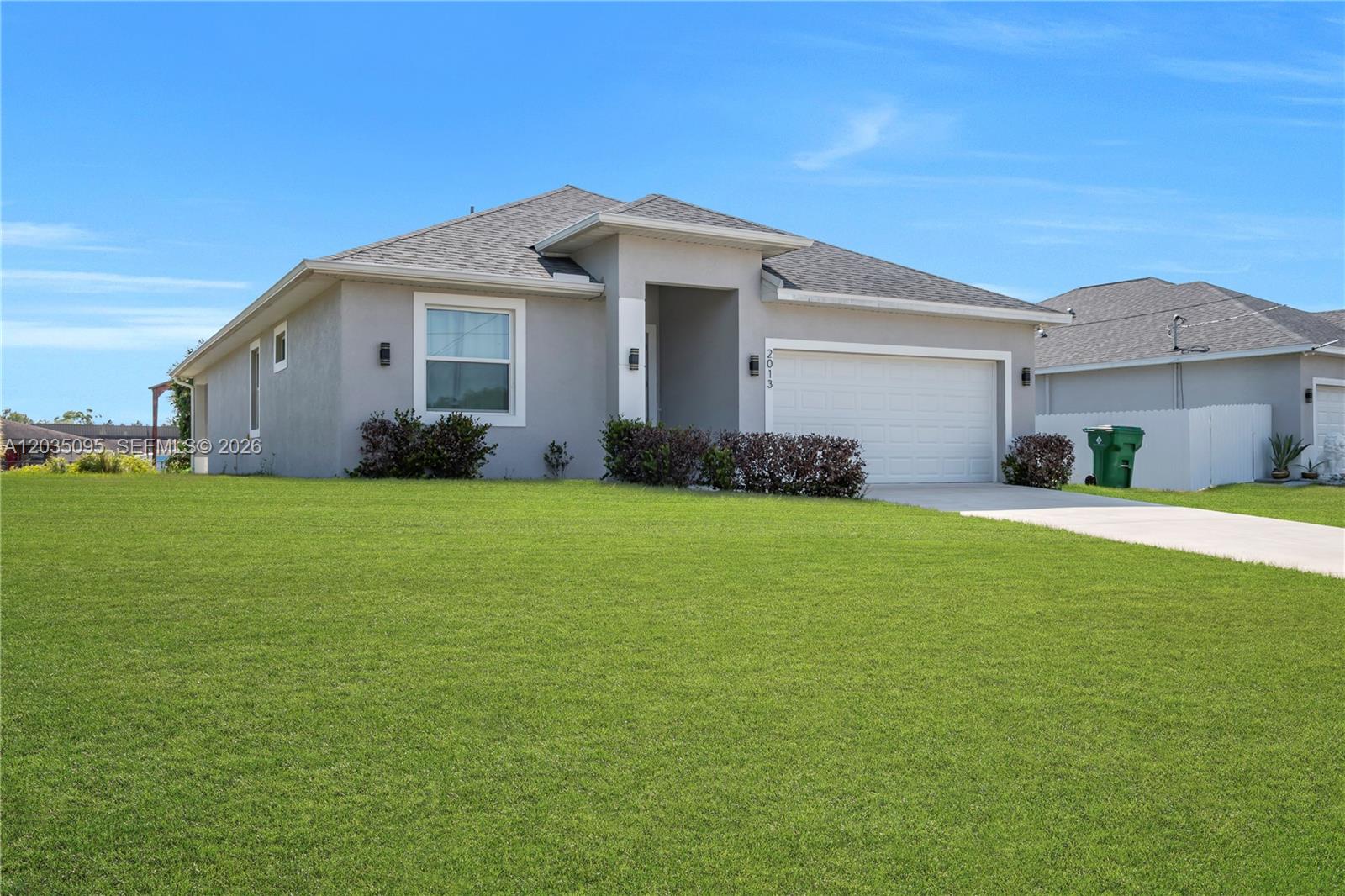 A single-story gray house with a two-car garage and a large front lawn — 2013 Inglewood, La Belle FL 33935, LA BELLE, FL