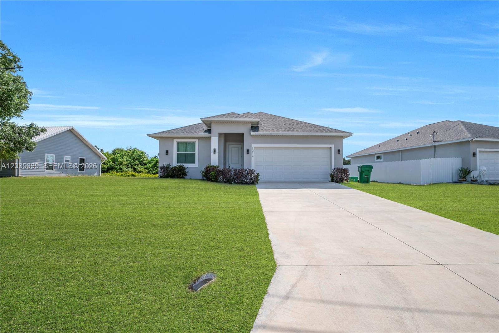 A single-story house with a gray exterior, a two-car garage, and a large front lawn — 2013 Inglewood, La Belle FL 33935, LA BELLE, FL
