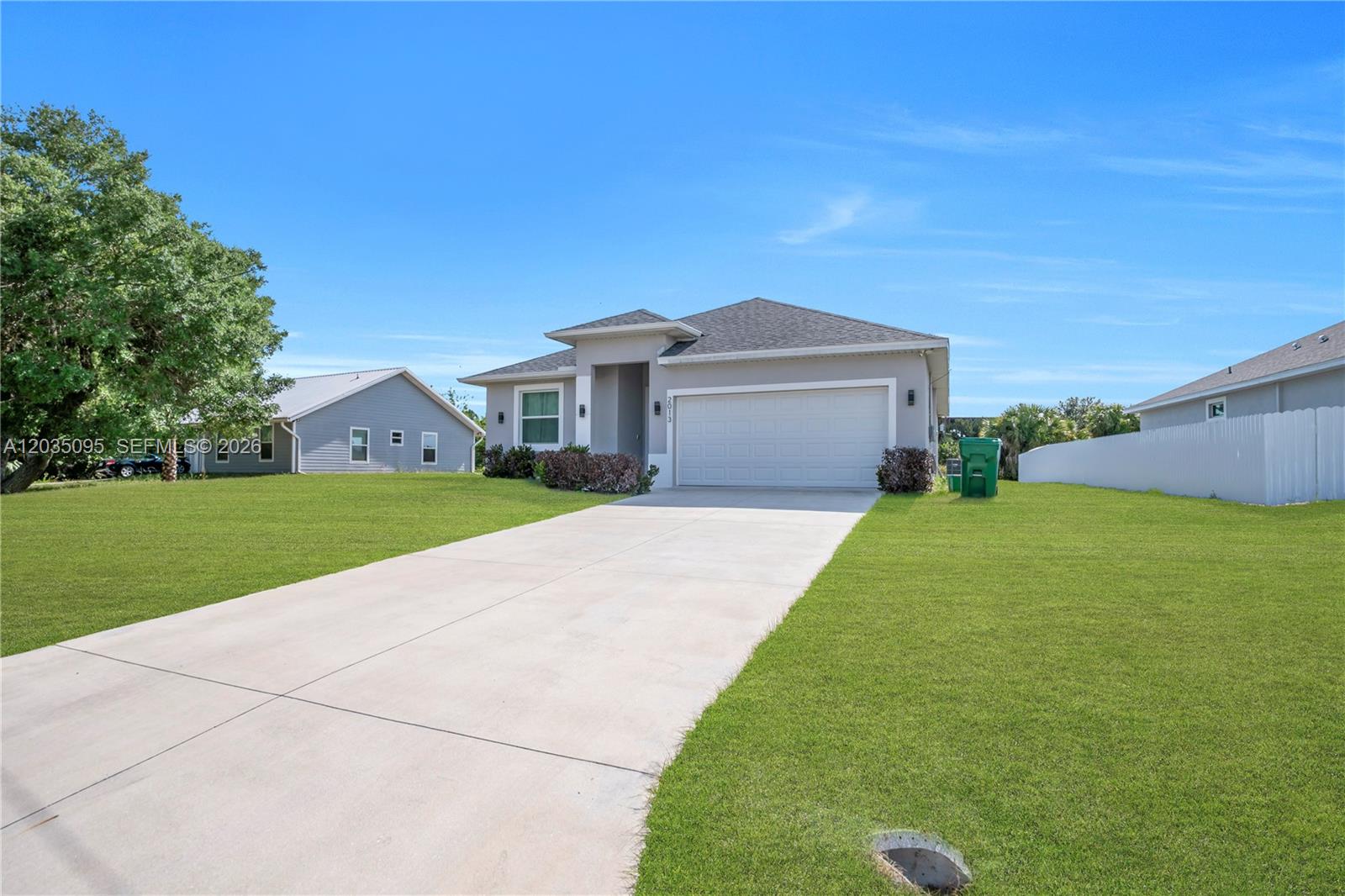 A single-story house with a gray exterior, a two-car garage, and a concrete driveway — 2013 Inglewood, La Belle FL 33935, LA BELLE, FL