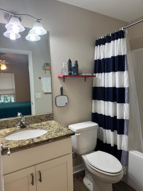 A bathroom features a granite vanity, a toilet, and a navy and white striped shower curtain — 2130 88th Avenue, Vero Beach FL 32966, VERO BEACH, FL