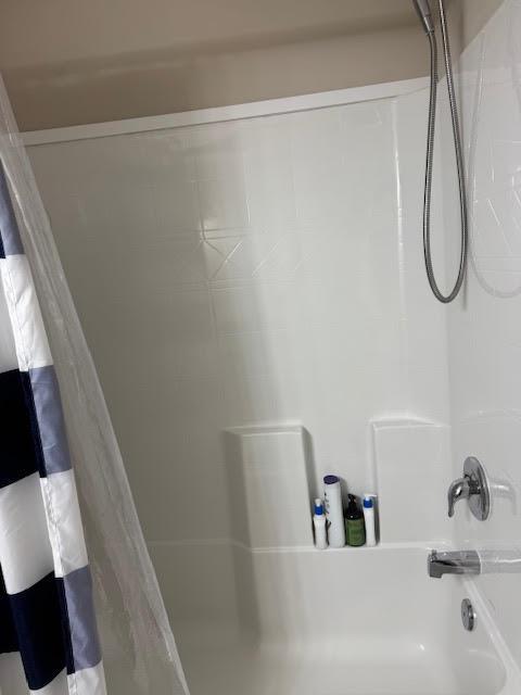 A white bathtub and shower surround with a handheld showerhead and a striped curtain — 2130 88th Avenue, Vero Beach FL 32966, VERO BEACH, FL