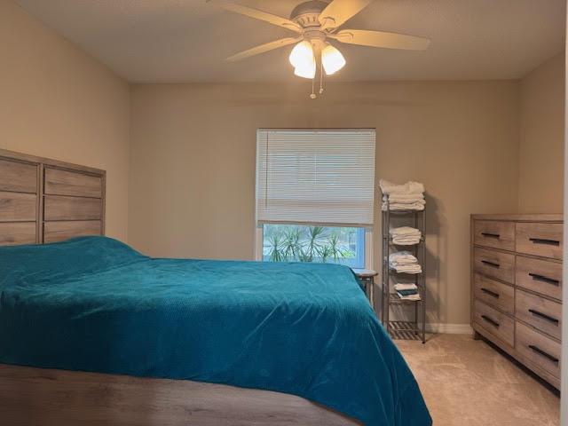 A bedroom features a teal bedspread, a wooden headboard and dresser, and a ceiling fan — 2130 88th Avenue, Vero Beach FL 32966, VERO BEACH, FL