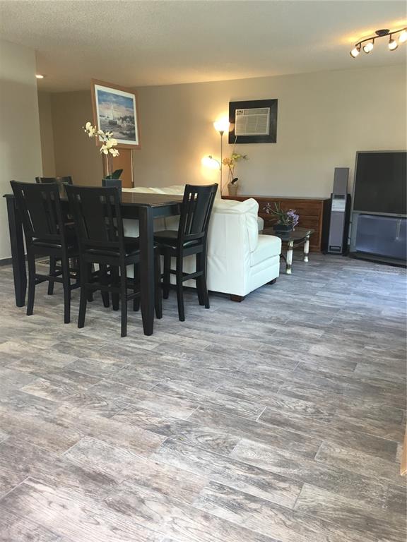 A living and dining area features wood-look tile flooring, a dark dining set, and furniture — 202 W PATTERSON STREET UNIT B, TAMPA, FL