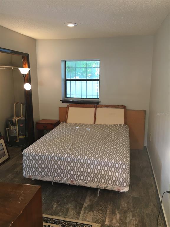 A bedroom features a bed with a patterned cover, a window with bars, and flooring — 202 W PATTERSON STREET UNIT B, TAMPA, FL