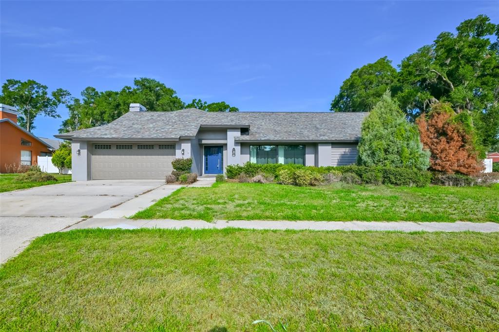 A single-story house with a gray exterior, a two-car garage, and a blue front door — 2701 HERNDON STREET, VALRICO, FL