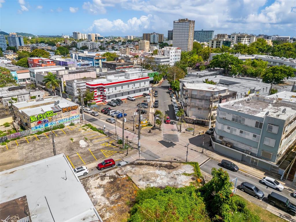An aerial view shows a city street intersection with parking lots, buildings, and parked cars — 1053 BRUMBAUGH, SAN JUAN, PR