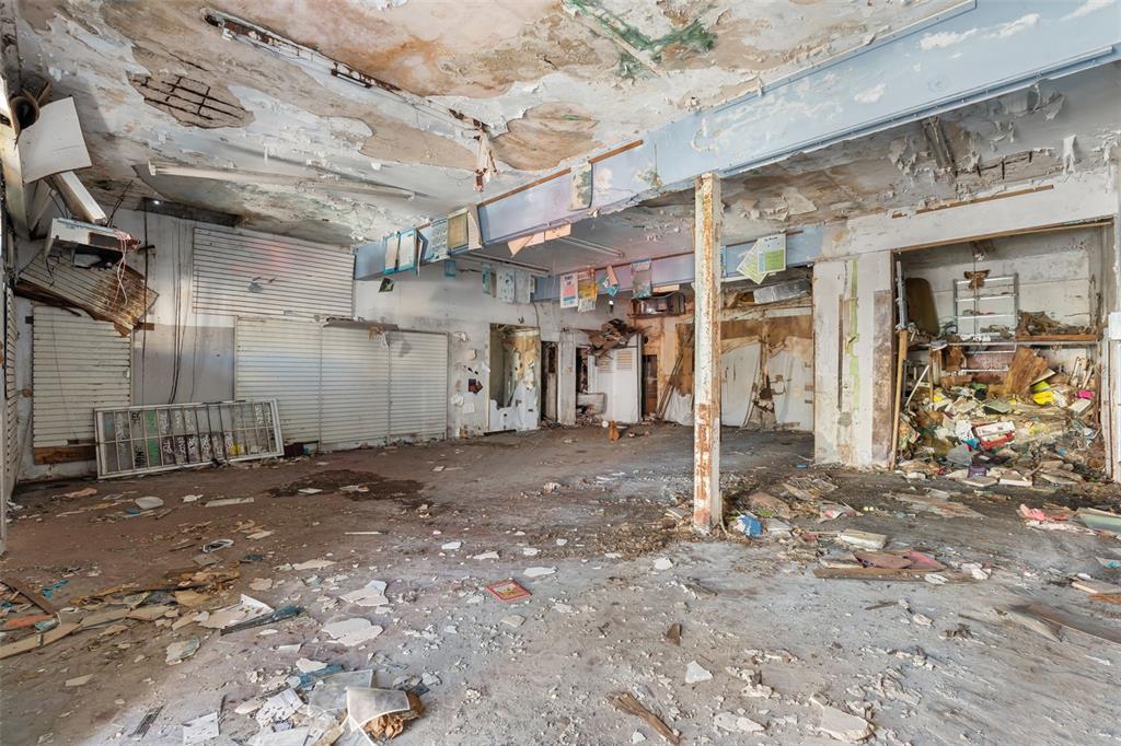 An abandoned, dilapidated commercial interior with peeling ceiling paint, debris-covered floors, and exposed structural supports — 1053 BRUMBAUGH, SAN JUAN, PR
