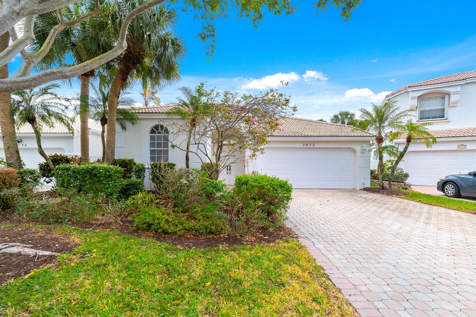 A single-story house with a white stucco exterior, a two-car garage, and a paved driveway — 2072 Chagall Circle, West Palm Beach FL 33409, WEST PALM BEACH, FL