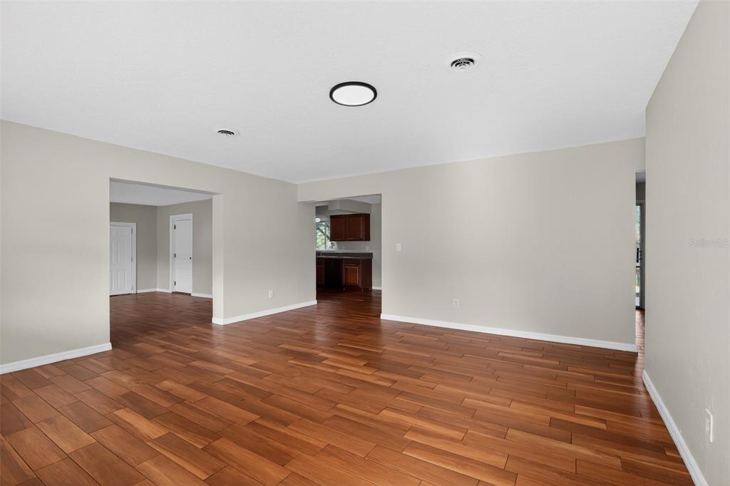 A spacious living area features light-colored walls, recessed lighting, and dark wood-look flooring — 4600 NE 22ND AVENUE, OCALA, FL