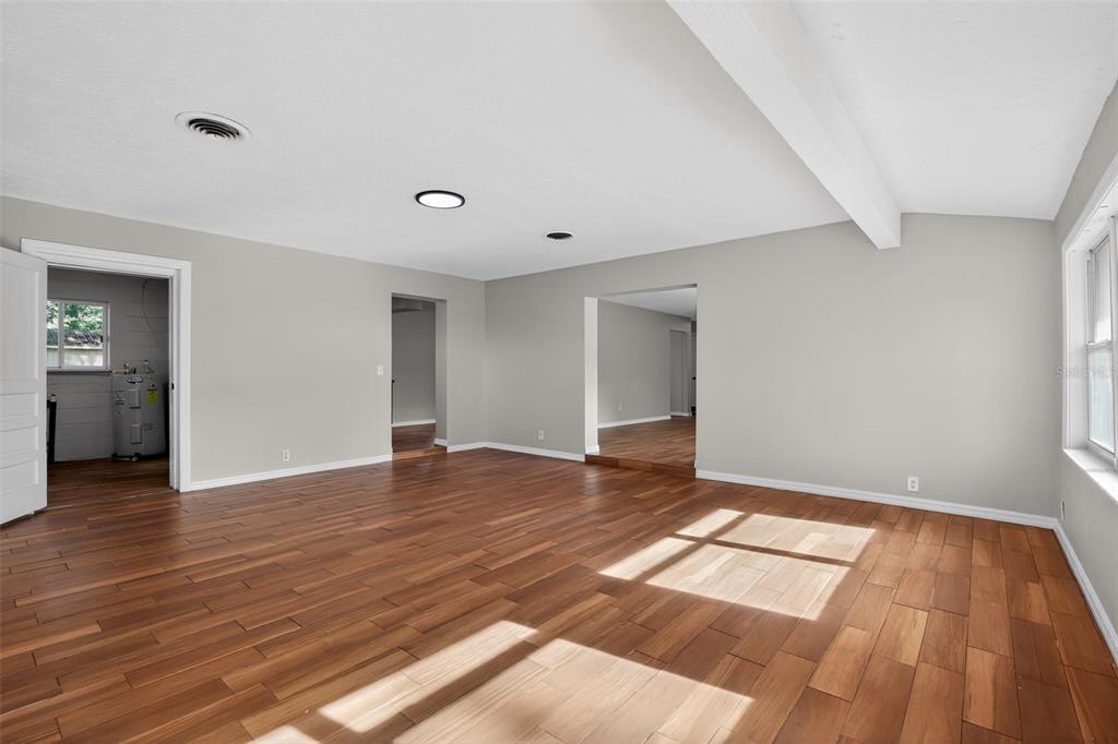 An empty room with wood-look flooring, white walls, and two doorways leading to other spaces — 4600 NE 22ND AVENUE, OCALA, FL