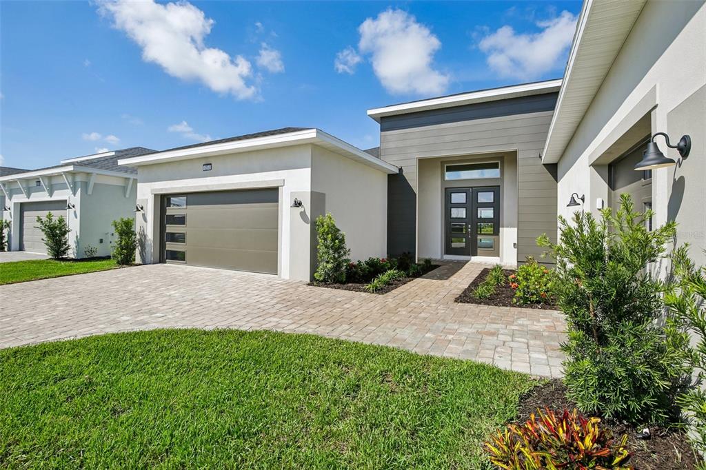 A modern single-story house exterior features a paved driveway, a garage, and a front entrance — 8255 GOLDEN BEACH COURT, PARRISH, FL