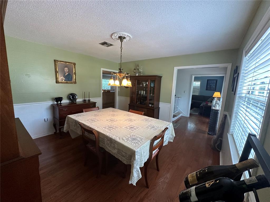 A dining room features a table with a patterned cloth, wood furniture, and green walls — 1105 S 9TH STREET, LEESBURG, FL