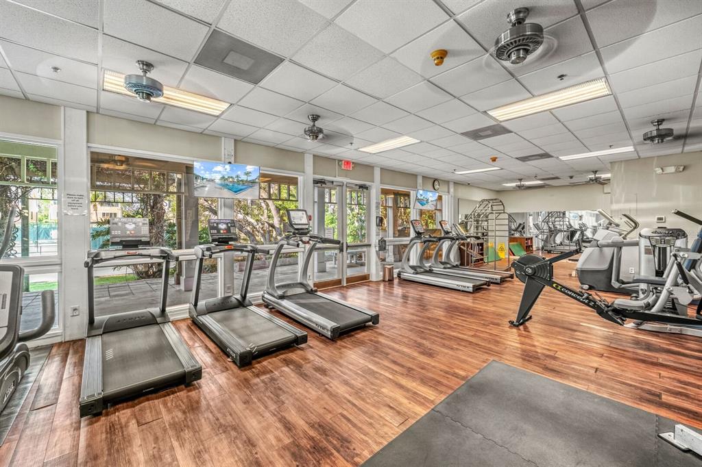 A gym with wood-look flooring, multiple treadmills, a rowing machine, and ceiling fans — 578 - 580 COMPANION WAY, LONGBOAT KEY, FL