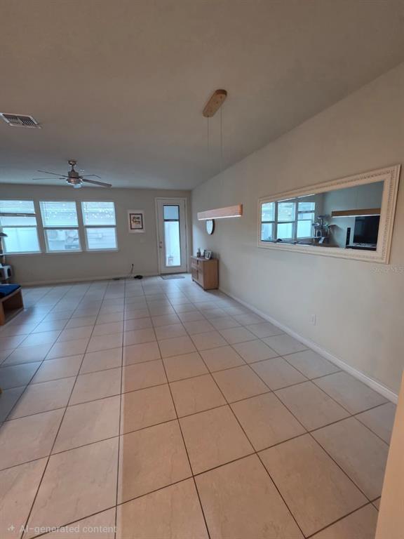 A spacious room features light-colored tile flooring, a ceiling fan, and a large wall mirror — 9740 BROWN BURROW STREET, ORLANDO, FL