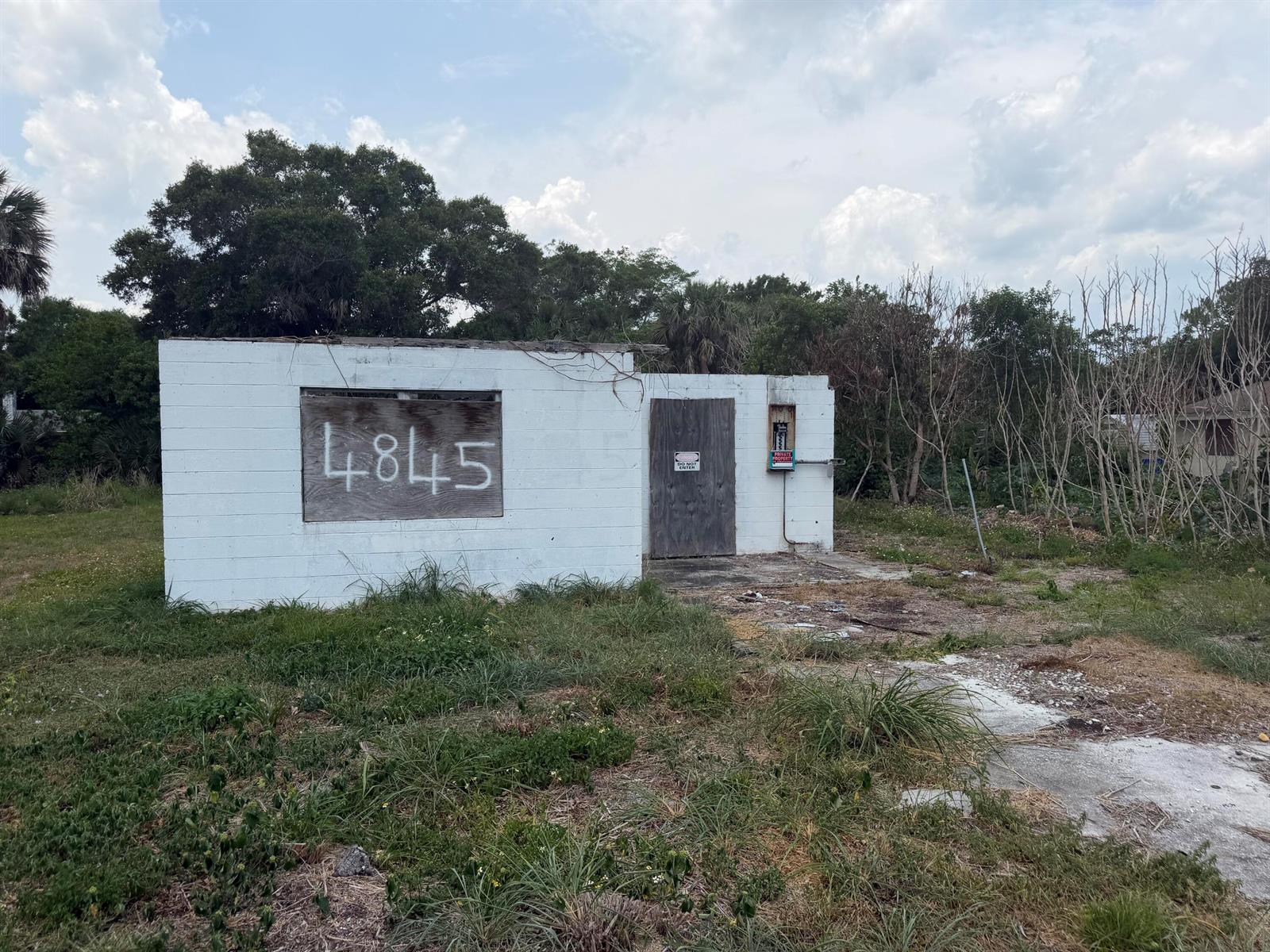 A small, white, concrete block building with a boarded-up window and a wooden door — 4845 34th Avenue, Vero Beach FL 32967, VERO BEACH, FL