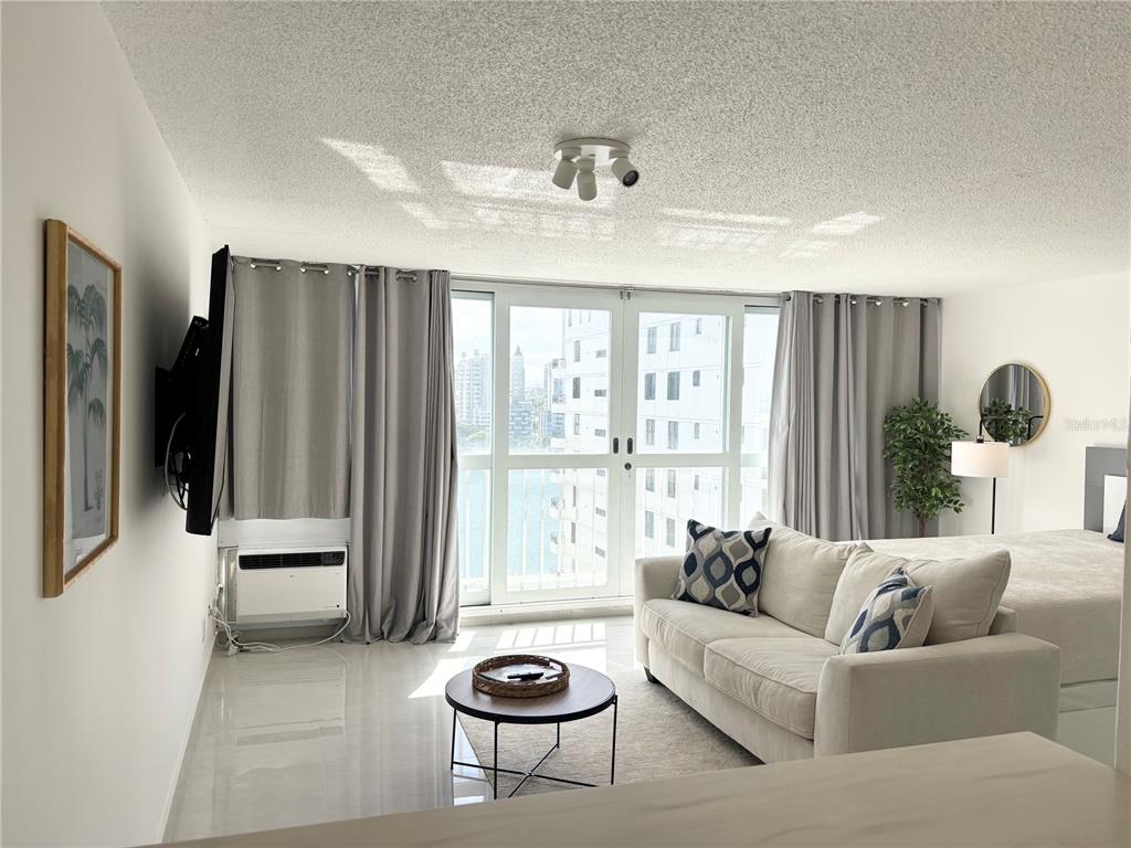 A living room features a sofa, a coffee table, and a balcony with city views — 1035 ASHFORD AVENUE UNIT 1108, SAN JUAN, PR