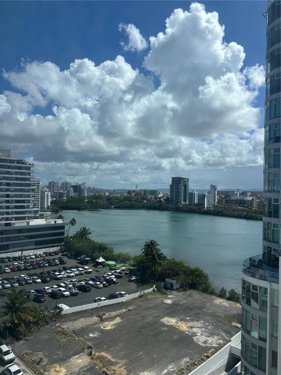 An elevated view of a parking lot, a body of water, and surrounding city buildings — 1035 ASHFORD AVENUE UNIT 1108, SAN JUAN, PR