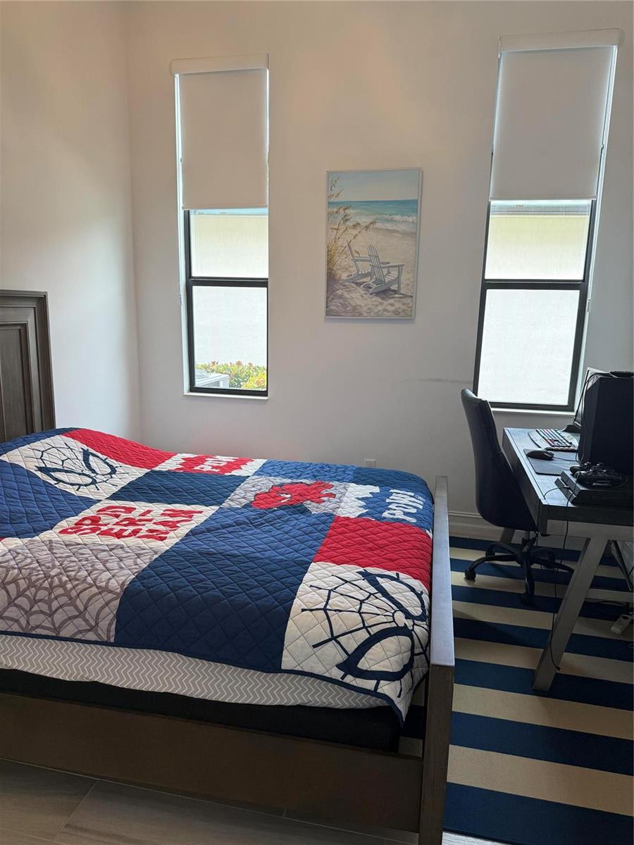 A bedroom features a Spider-Man themed quilt on a bed, a desk, and two windows — 8467 Grand Prix Lane, Boynton Beach FL 33472, BOYNTON BEACH, FL