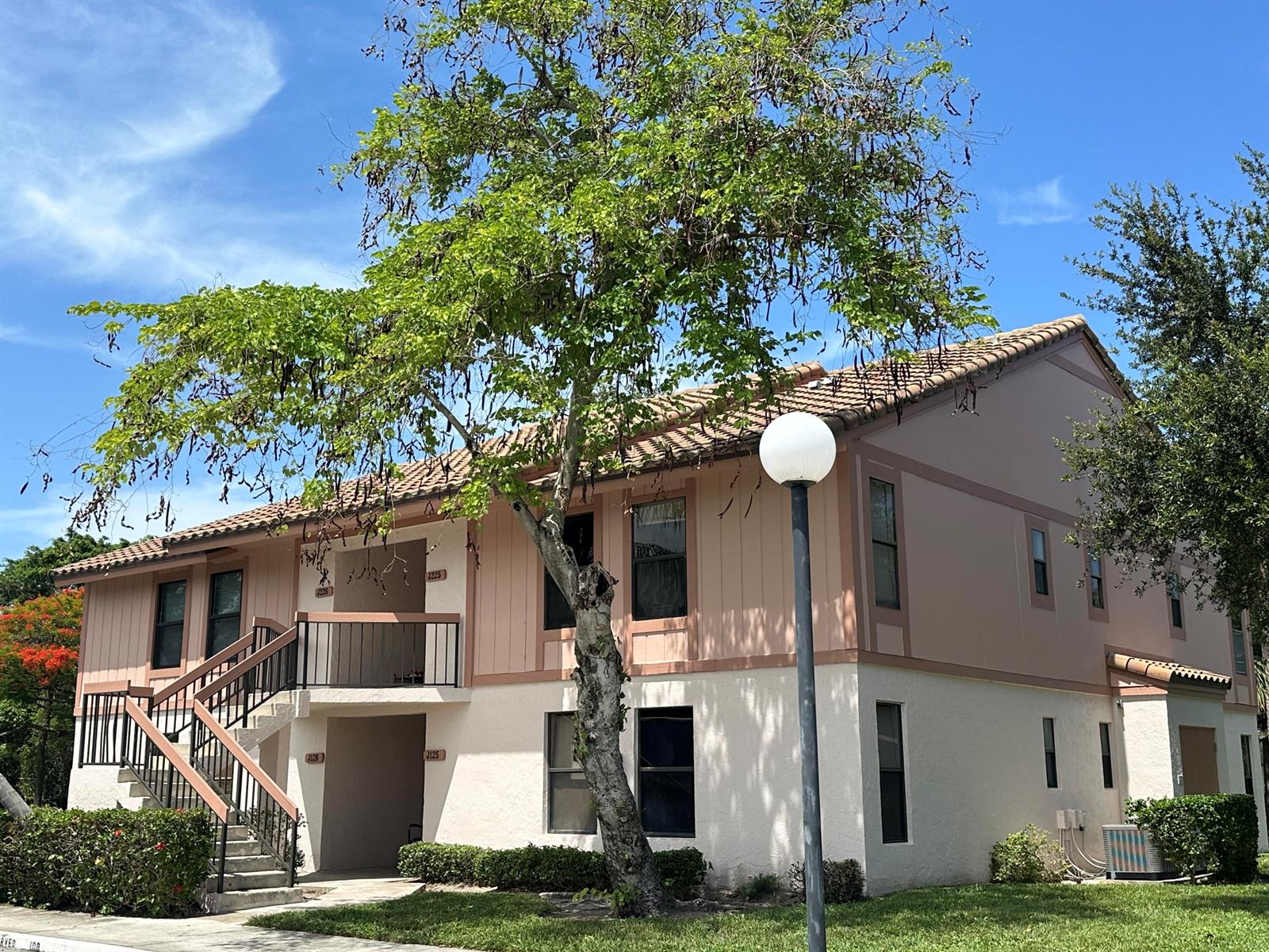 A two-story apartment building with a tiled roof, exterior stairs, and a large tree — 3380 Jaywood Terrace # 1250, Boca Raton FL 33431, BOCA RATON, FL