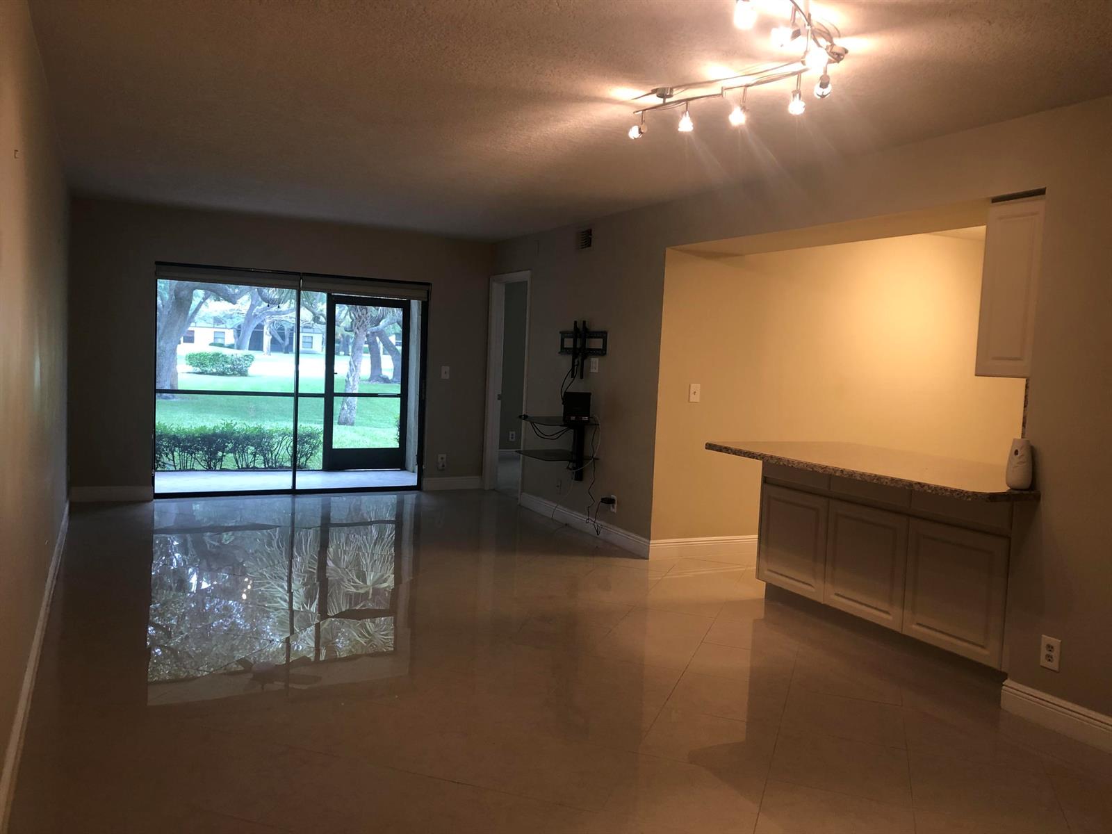 An open living area with tile floors, a breakfast bar, and a sliding glass door — 3380 Jaywood Terrace # 1250, Boca Raton FL 33431, BOCA RATON, FL