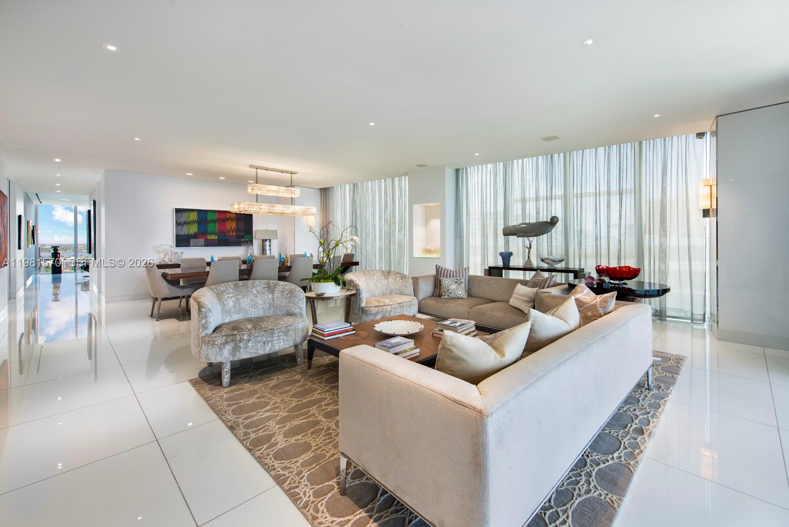 A modern, open-concept living and dining area features white tile floors and floor-to-ceiling windows — 9705 Collins Ave # 1702N, Bal Harbour FL 33154, BAL HARBOUR, FL