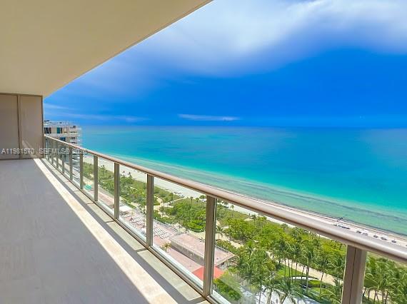 A high-rise balcony overlooks a sandy beach and the turquoise ocean under a blue sky — 9705 Collins Ave # 1702N, Bal Harbour FL 33154, BAL HARBOUR, FL