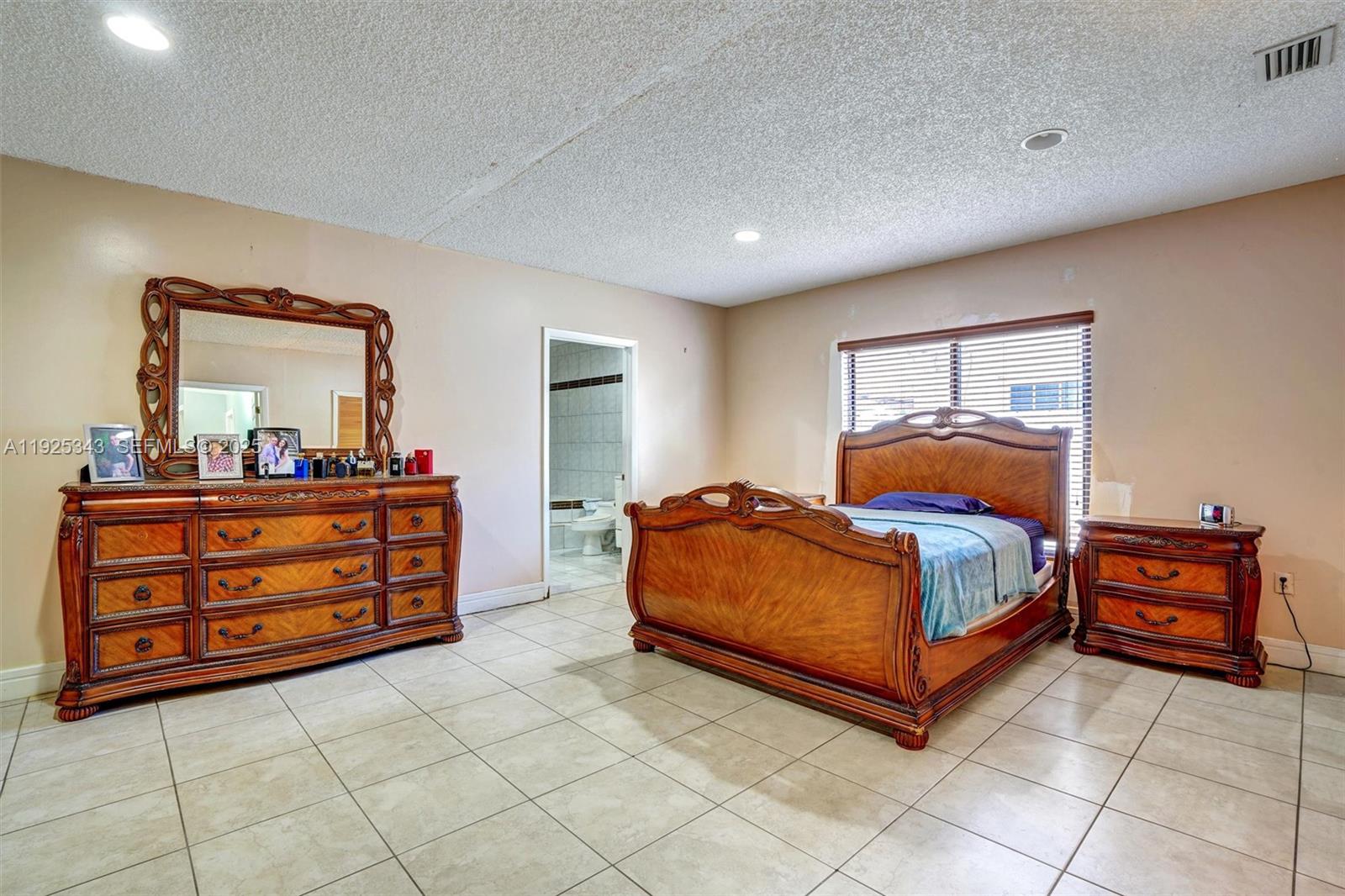 A living room features light gray walls, tile flooring, two leather sofas, and a coffee table — 631 E 53rd St, Hialeah FL 33013, HIALEAH, FL