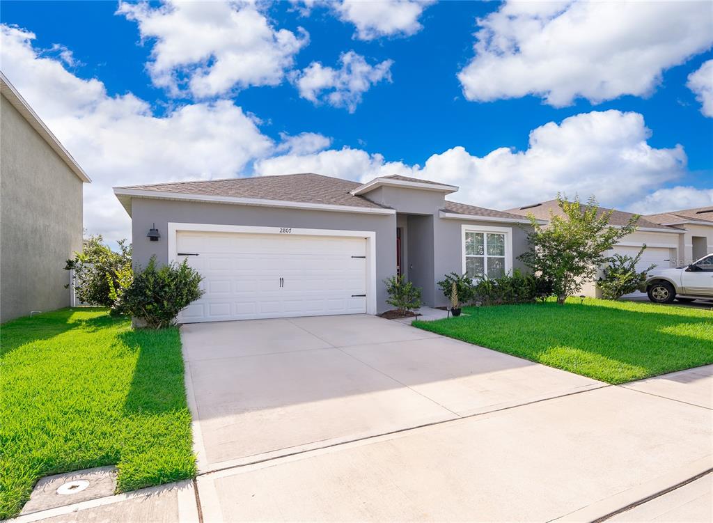 An aerial view shows a single-story suburban house outlined in red with a concrete driveway — 2807 HARMONIA HAMMOCK ROAD, HARMONY, FL