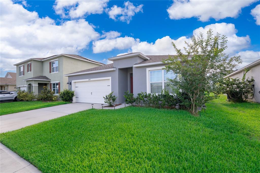 An aerial view shows several suburban houses with shingled roofs, driveways, and backyards — 2807 HARMONIA HAMMOCK ROAD, HARMONY, FL