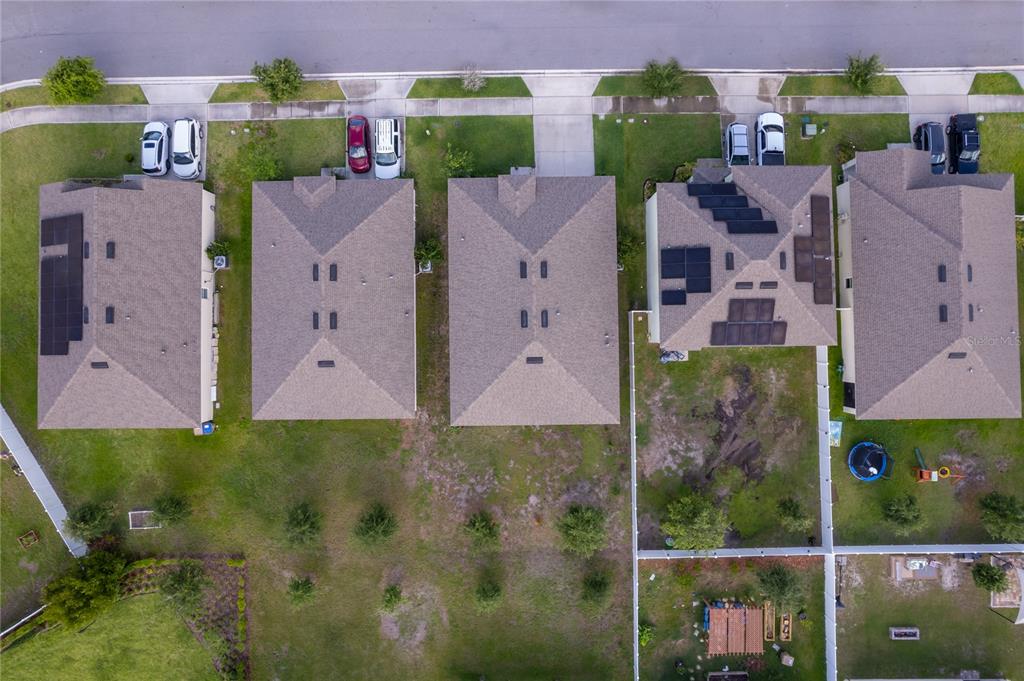 A single-story gray house with a two-car garage and a front lawn under a sky — 2807 HARMONIA HAMMOCK ROAD, HARMONY, FL