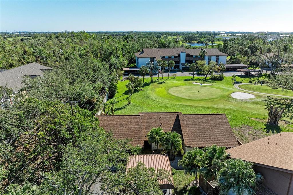 An aerial view shows residential buildings situated next to a golf course green — 4644 RED MAPLE ROAD UNIT 1303, BRADENTON, FL