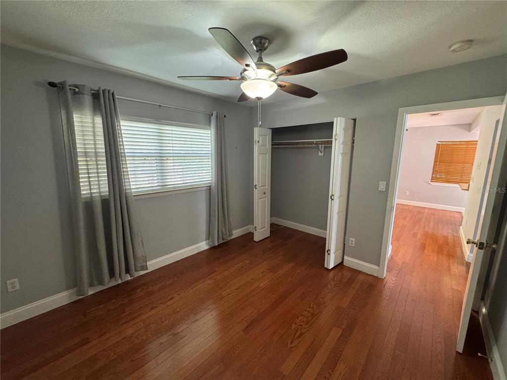 A bedroom features gray walls, hardwood floors, a ceiling fan, and an open closet — 2276 RAEFORD ROAD UNIT A4, ORLANDO, FL