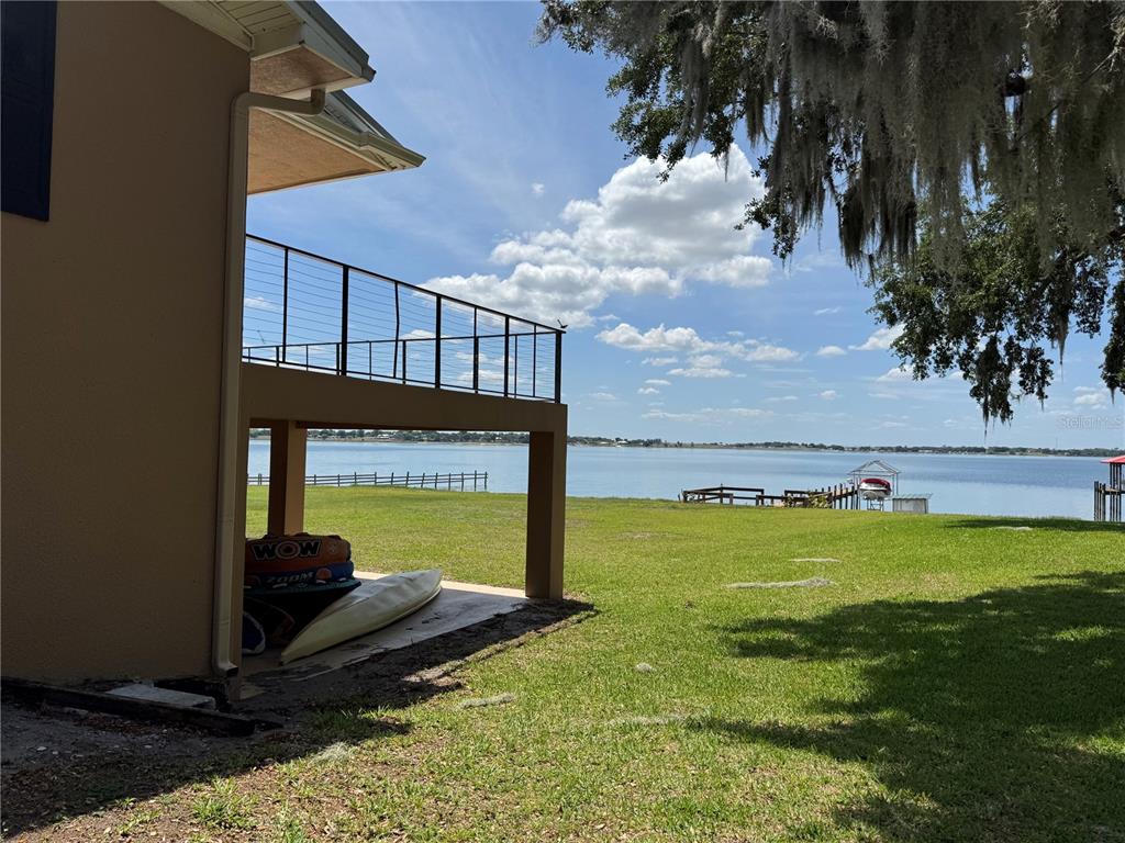 A view of a lake from beneath a raised deck with a kayak and inflatables — 607 W STATE ROAD 630, FROSTPROOF, FL