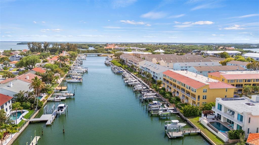 An aerial view of a canal lined with residential buildings, boat docks, and private pools — 1071 PINELLAS BAYWAY S, ST PETERSBURG, FL