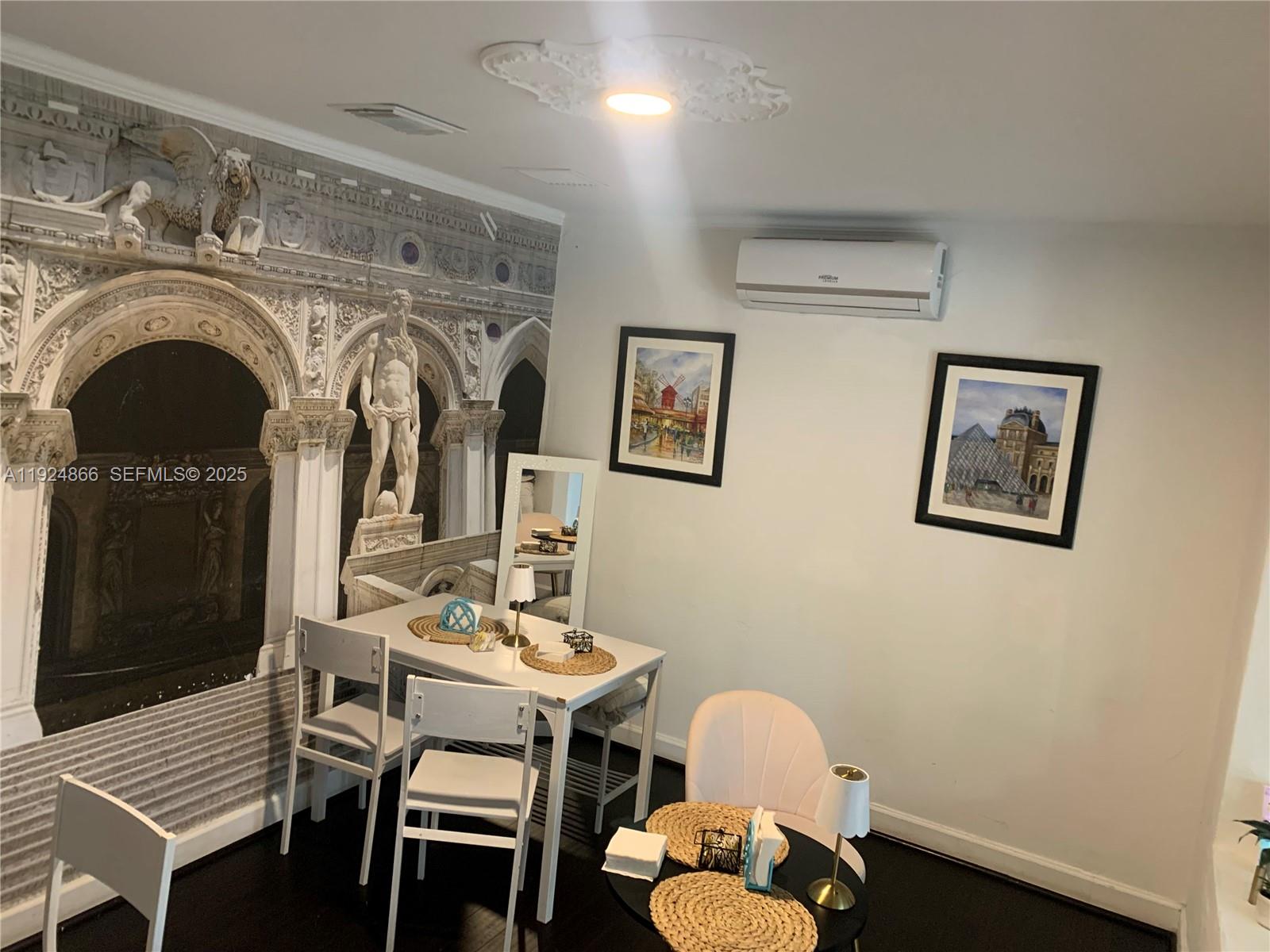 A dining area features a mural wall, a white table with chairs, and framed artwork — 1239 Alton Rd, Miami Beach FL 33139, MIAMI BEACH, FL