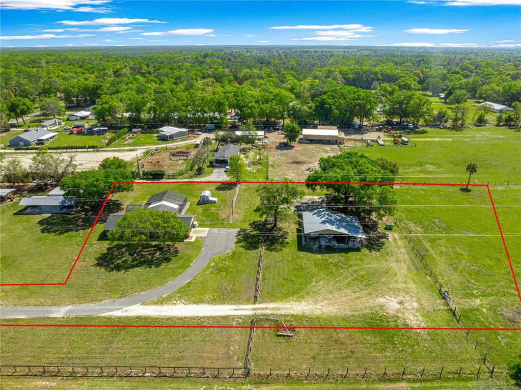 An aerial view shows a rural property with two houses, outbuildings, and fenced pastures — 2940 NE 49TH STREET, OCALA, FL
