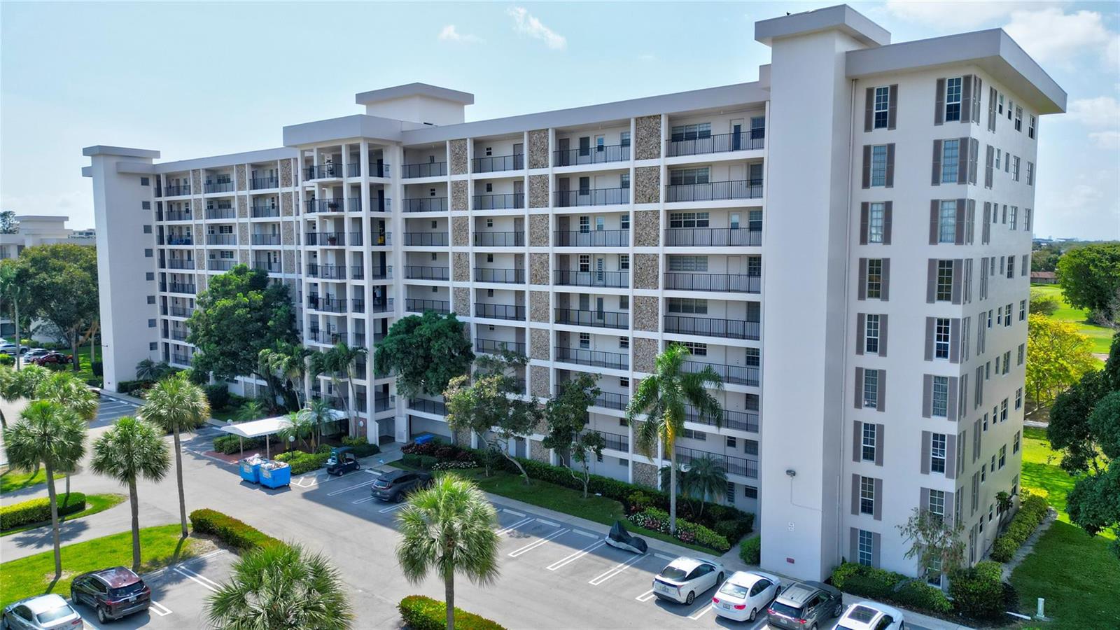 An exterior view of a multi-story apartment building with balconies and a parking lot — 3050 N Palm Aire Drive # 505, Pompano Beach FL 33069, POMPANO BEACH, FL
