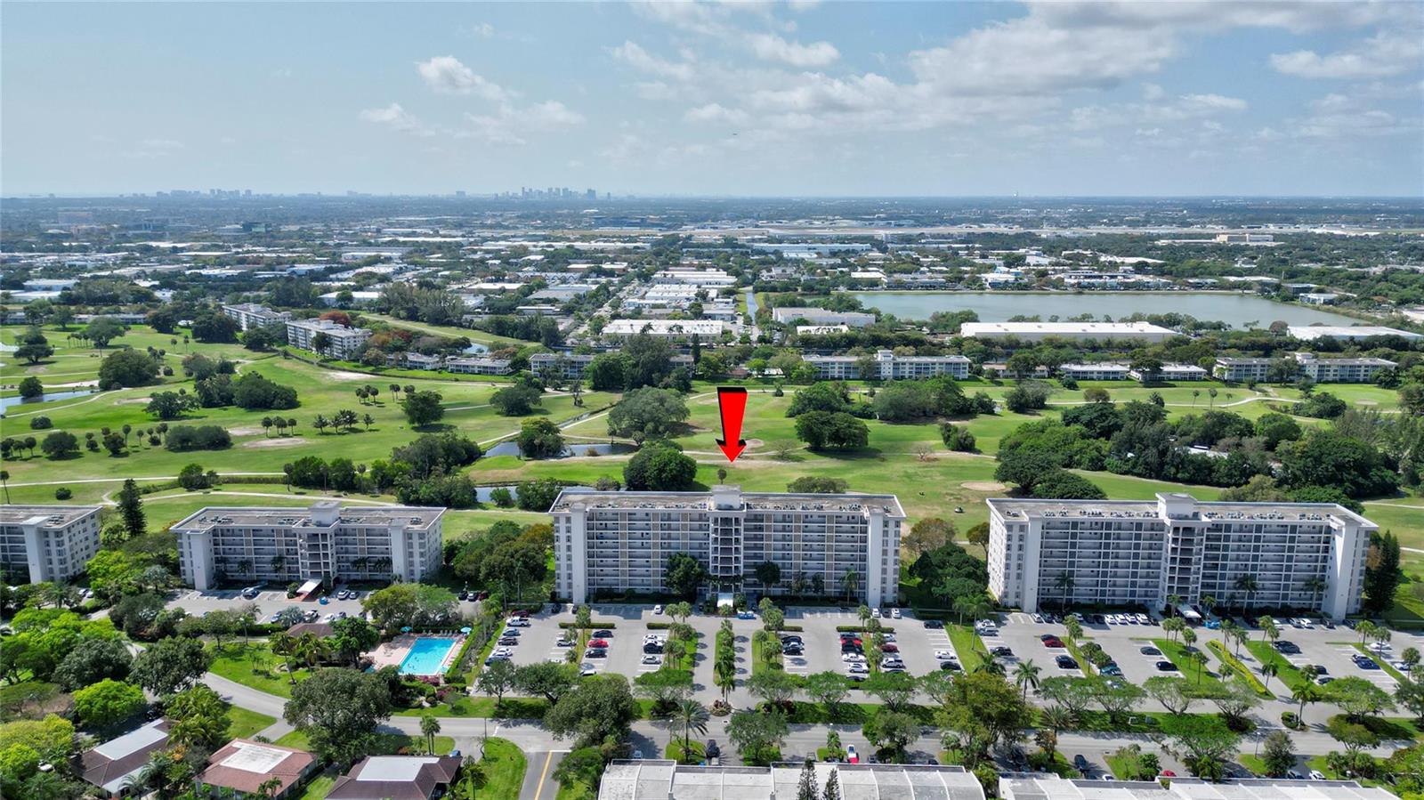 An aerial view shows three multi-story apartment buildings surrounded by a golf course and parking — 3050 N Palm Aire Drive # 505, Pompano Beach FL 33069, POMPANO BEACH, FL