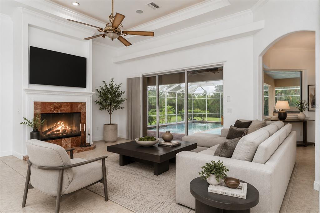 A screened-in swimming pool and spa area with a blue deck and surrounding lush landscaping — 6120 9TH AVENUE CIRCLE NE, BRADENTON, FL