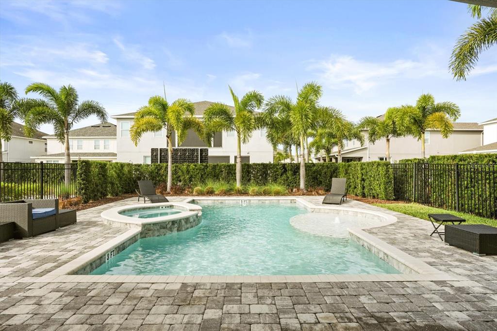 A backyard swimming pool with a spa, fountain, and lounge chairs on a paver patio — 421 SOUTHFIELD STREET, KISSIMMEE, FL