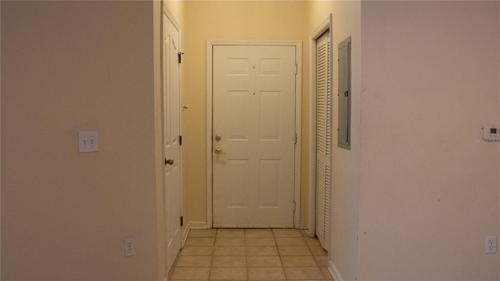 A foyer features a tiled floor, a white front door, and two adjacent interior doors — 12861 MADISON POINTE CIRCLE UNIT 106, ORLANDO, FL